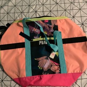 A pink multi colored duffel bag.